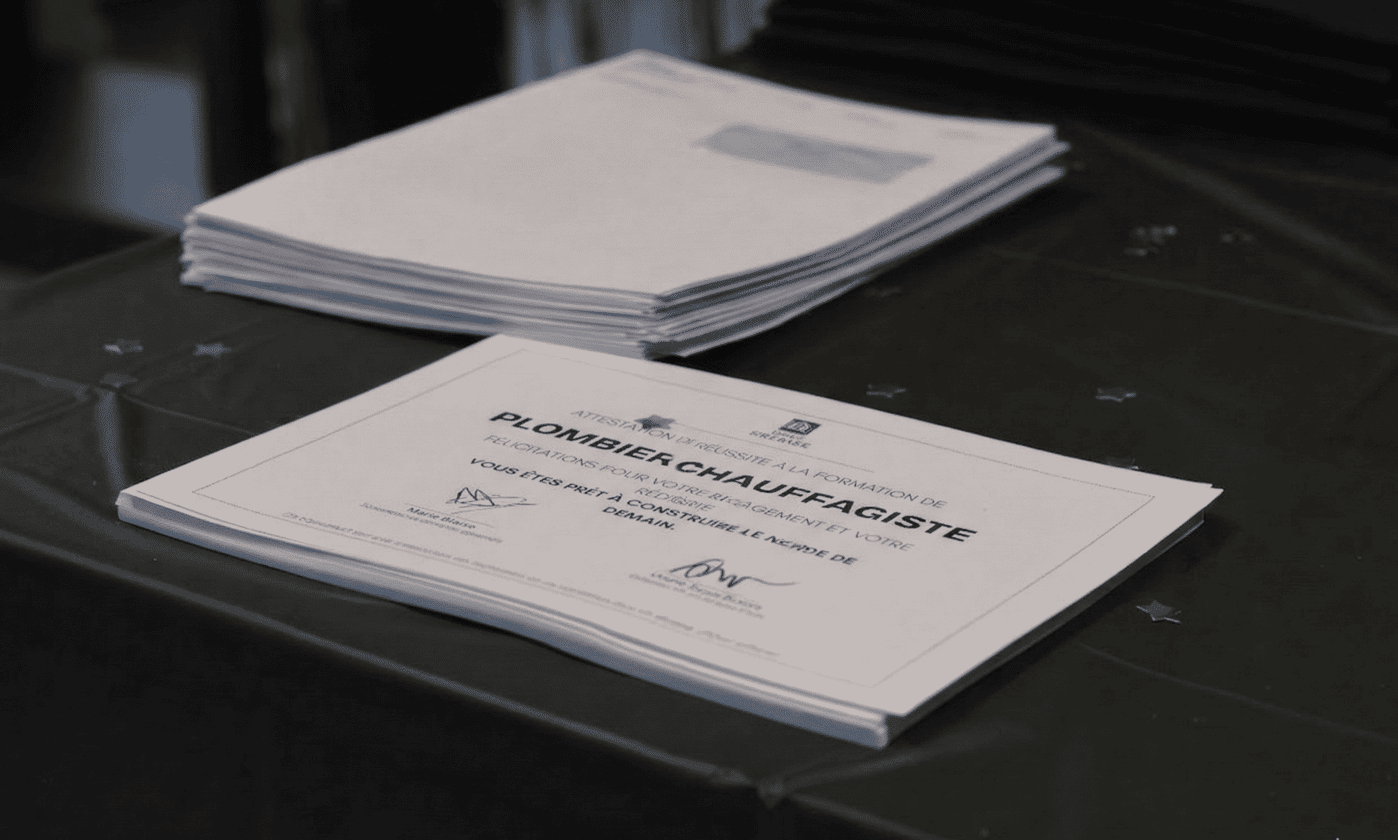 Certificat de fin de formation plombier chauffagiste posé sur une table lors d’une remise de diplômes à l’École Gustave.