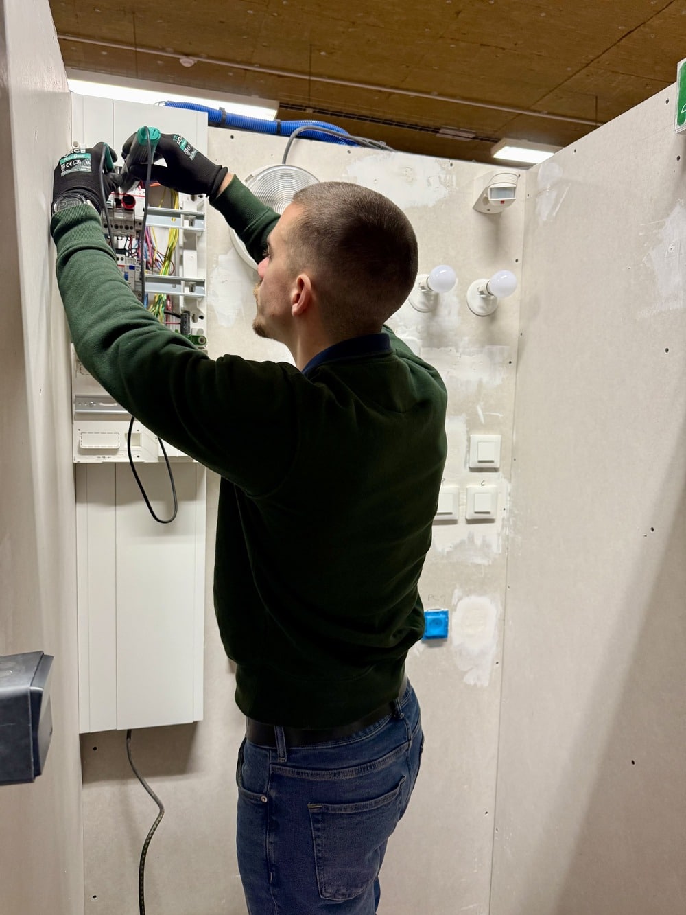 Un apprenant qui réalise une installation électrique pour se former au métier d’électricien au sein de l’École Gustave.