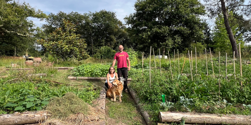 Karine, Frédéric et leurs deux chiens au milieu de leur potager